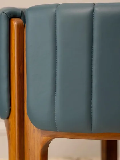 The seamless joinery where the upholstered back meets the wooden frame of the accent chair. This detail highlights the precision and care that goes into each piece I create.
