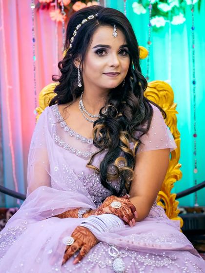 A classic portrait of the bride-to-be seated, showcasing her beautiful lavender gown and hairstyle.