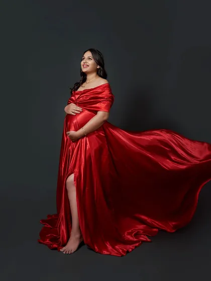 A beautiful shot of the red Valentina gown in motion. The satin fabric catches the light, and the flowing trail creates a stunning effect.