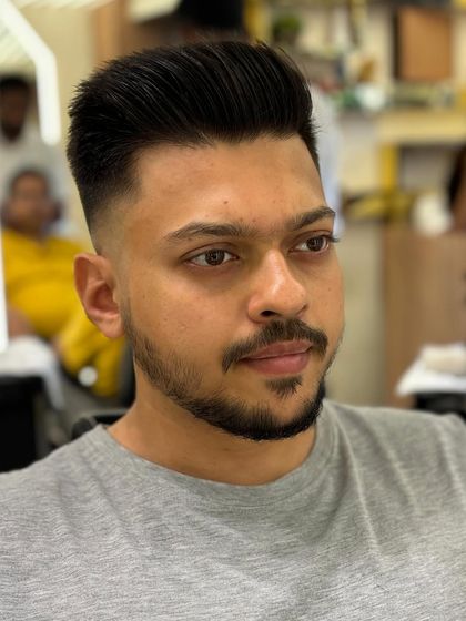 A frontal view of a client's fresh haircut, featuring a voluminous top and a clean fade.