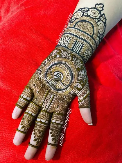 A circular peacock design on the palm, surrounded by delicate patterns. This style is very popular for both brides and guests.