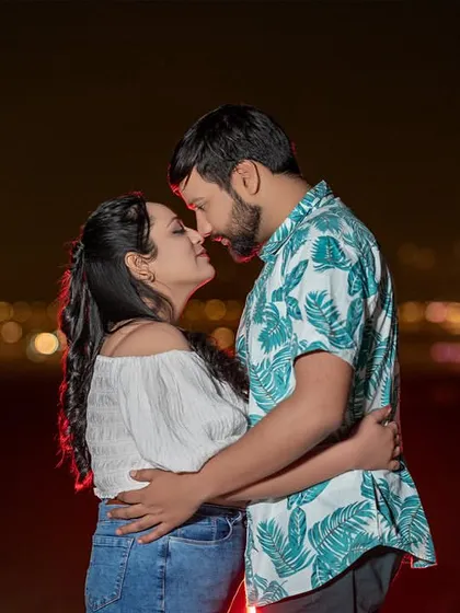 An intimate close-up against the blurred city lights. This shot focuses purely on the couple's connection, with the sparkling background adding a touch of urban romance to the scene.