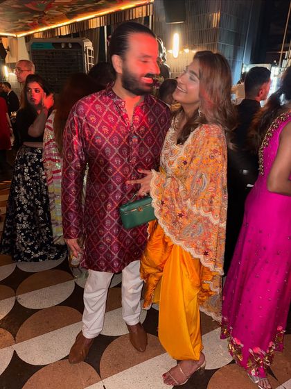 A candid moment from a wedding event. I'm wearing a vibrant yellow Anamika Khanna dhoti set, which is both comfortable and incredibly stylish for a night of dancing.