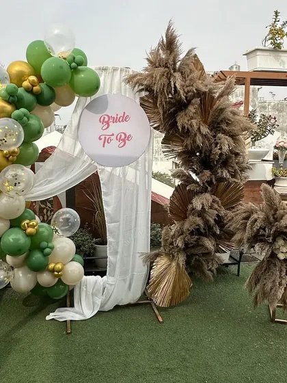 The full view of the chic bridal shower backdrop, showing the combination of the pampas grass arch and the modern balloon garland.