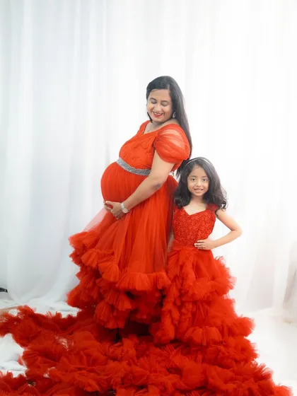 I love creating matching outfits for the whole family. This mother and daughter duo in coordinated red ruffle gowns is a perfect example of how you can create beautiful, coordinated memories for maternity shoots or family functions.