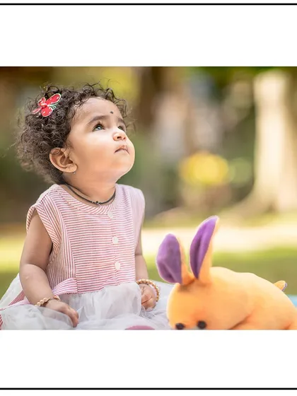 A moment of wonder captured in a park. The soft, natural light of an outdoor setting is perfect for these gentle and curious portraits.