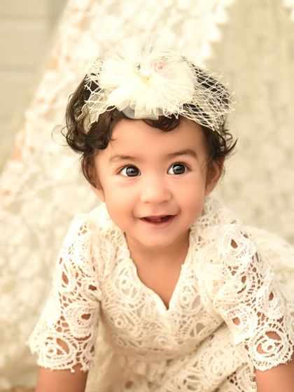 A beautiful close-up from a boho first birthday shoot. Her delicate lace dress and the soft background create a dreamy and innocent portrait.