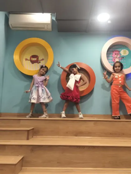 Three friends strike a pose on our tiered steps, showing off their party outfits and fun personalities.