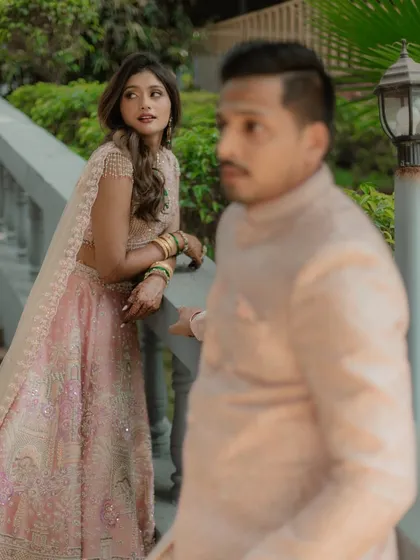An artistic shot using depth of field, with the bride in focus looking towards her partner in the foreground.