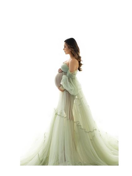 A minimalist version of an elegant portrait. The simple white background makes the beautiful silhouette of the mother and her flowing gown the complete focus.