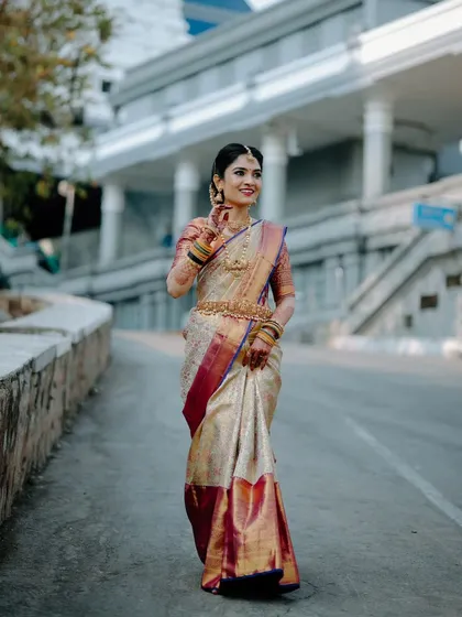 A full-length portrait of the bride on the street, capturing a candid, in-motion feel. It showcases her entire traditional look in a unique, urban-style setting.