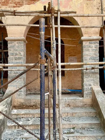 A repeat image of the entrance porch under scaffolding, highlighting the scale of the restoration effort.