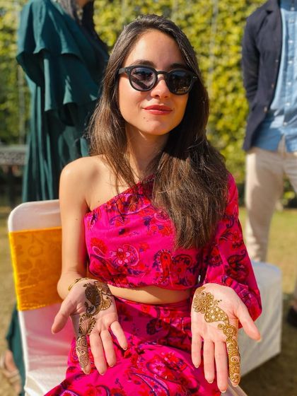 The client displaying her two simple hand designs, perfect for a modern and fun mehndi look.
