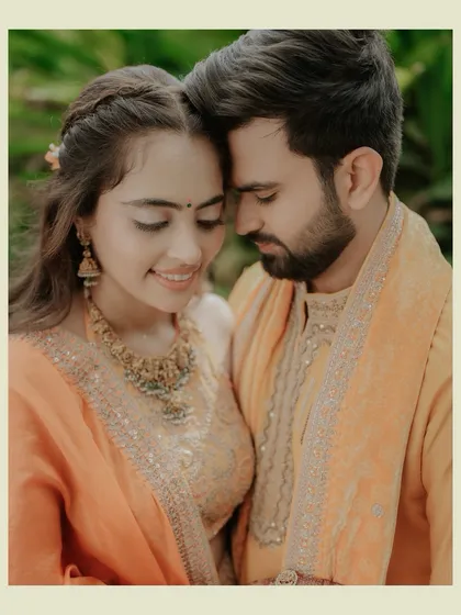 A warm and tender portrait of the couple in beautiful yellow and orange traditional wear. Their close embrace and gentle smiles radiate happiness and love.