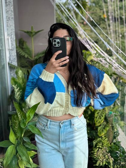 Another look at our blue patchwork cardigan, this time styled for a casual day out. The cropped fit pairs perfectly with high-waisted jeans, and the soft yarn makes it comfortable enough to wear all day.