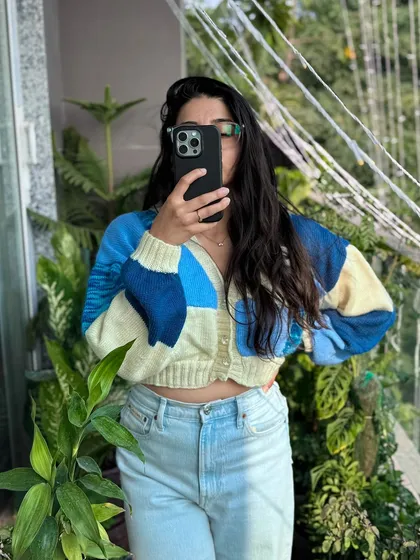 Another look at our blue patchwork cardigan, this time styled for a casual day out. The cropped fit pairs perfectly with high-waisted jeans, and the soft yarn makes it comfortable enough to wear all day.