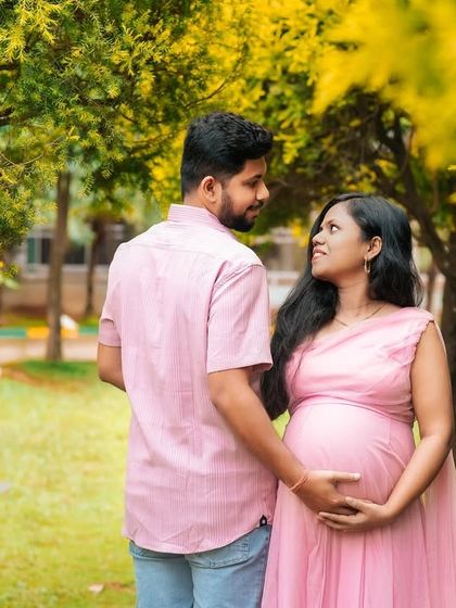 A candid, walking shot of an expecting couple in a park. Capturing these unposed moments of interaction results in authentic and heartfelt images.