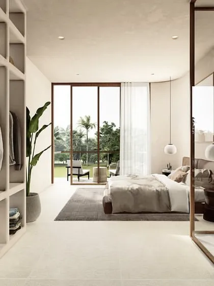 This view shows the seamless transition from a walk-in closet to the master bedroom in the Pavilions in the Fields project. The open-plan suite is connected by a shared material palette and views of the internal courtyard and landscape.