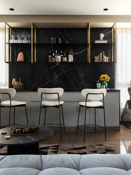 This bar and lounge area in Villa Aish was designed as a private retreat with a distinct, moody atmosphere. We combined dark marble, brass-accented shelving, and curated lighting to create a sophisticated space for entertainment, showcasing our ability to craft specific moods through material and light.