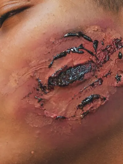 This close-up shows the detail of a facial scratch prosthetic. I carefully blend the edges of the appliance into the skin to ensure it looks like a genuine part of the face, even under intense lighting.