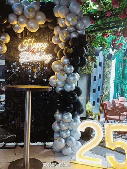 This angle shows how the balloon arch frames the sequin backdrop, adding dimension and a festive feel to the decor. The black and silver color scheme is both classic and celebratory.