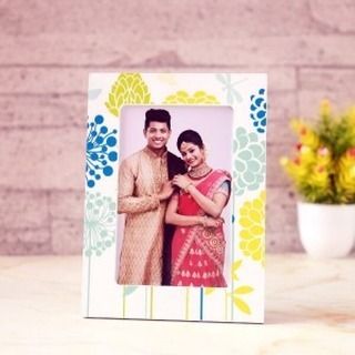 A simple and elegant personalized photo frame with a colorful floral border. It's a beautiful way to display a wedding photo or any other special memory on a desk or shelf.