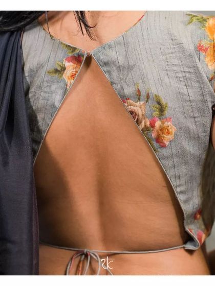 The blouse features a daring and modern open-back design, making a bold style statement.