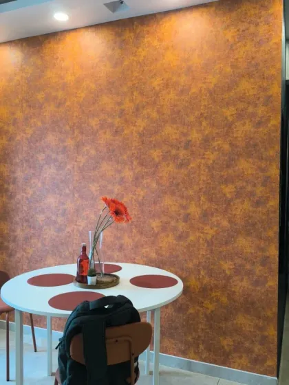 A textured wallpaper in a warm, rustic orange. This type of finish adds depth and character to a dining area, creating a cozy and inviting atmosphere.