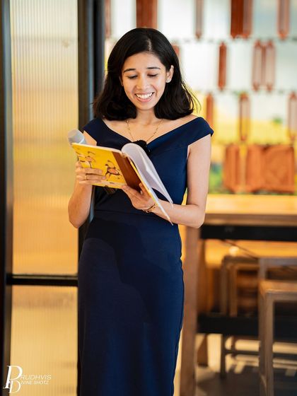 A poet reads from her journal, a smile on her face. Sharing vulnerabilities can be an empowering and joyful experience in the right community.