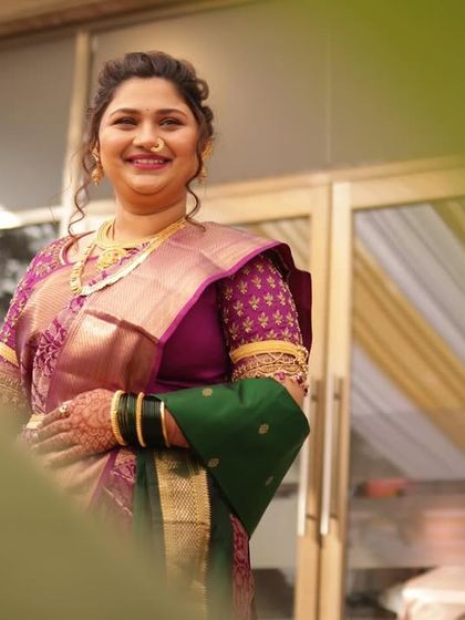 A candid shot of the bride, looking radiant and happy. The focus is on her traditional Maharashtrian saree and jewelry, styled to perfection for her big day.