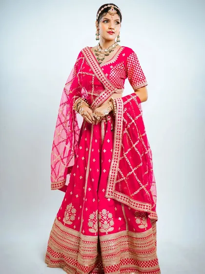 A full length standing pose to show the complete silhouette of this beautiful pink and gold lehenga.