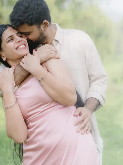 A warm, happy hug from behind. The soft focus and natural light enhance the feeling of comfort and intimacy in this candid moment.