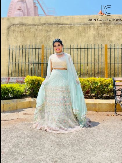 A client looking beautiful in a light blue lehenga, posing outdoors.