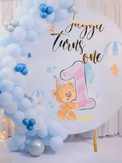 A close-up of a custom backdrop for a teddy bear themed first birthday. The personalized graphic and name add a special touch.