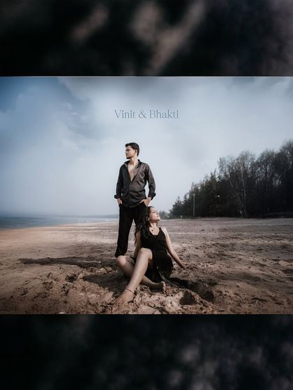 A wide-angle shot of a couple on a sandy beach, creating a dramatic and cinematic feel with the vast landscape.