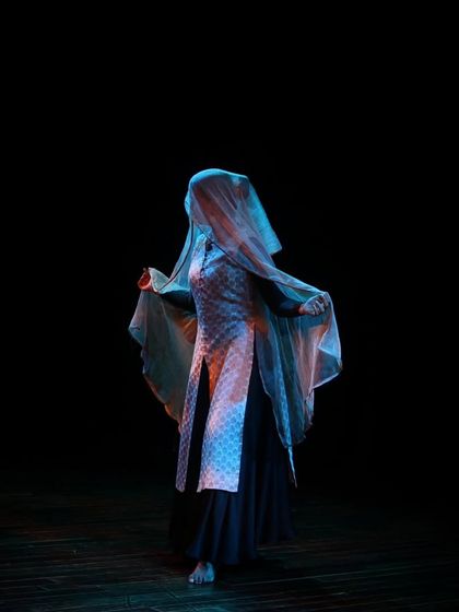 A dancer uses a veil to create a mysterious and evocative image on stage during a Kathak performance.