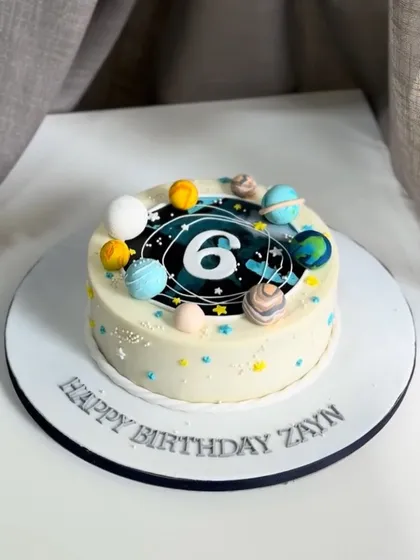 A galaxy-inspired cake for a 6th birthday! This design is filled with handcrafted fondant planets and stars, perfect for a little astronaut who dreams big.