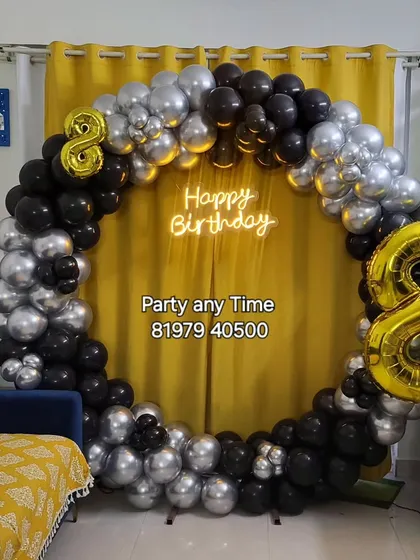 A black and silver circular balloon arch for an 8th birthday celebration at home.