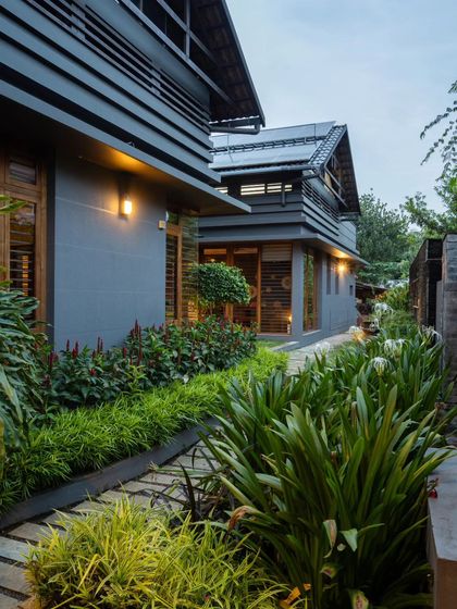 A narrow landscaped path runs along the side of the house, connecting the front and back gardens and enhancing the feeling of being surrounded by nature.