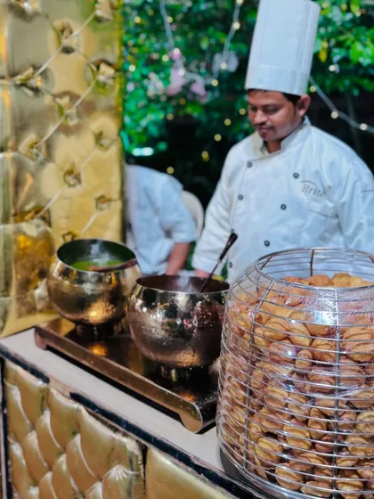 A chef at the pani puri station, a key attraction of the chaat counter, with a display of crispy puris.