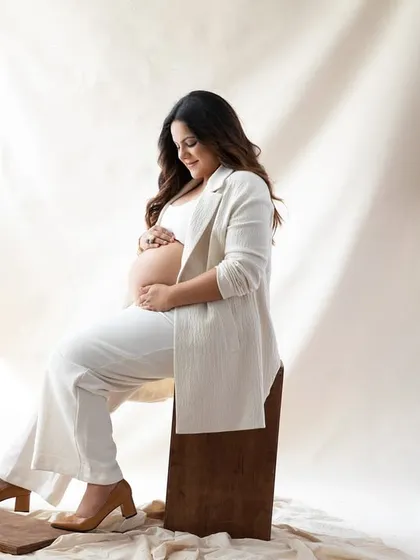 A chic and modern look with an all-white outfit against a soft, neutral backdrop. This style is perfect for creating a bright, airy, and sophisticated maternity portrait.