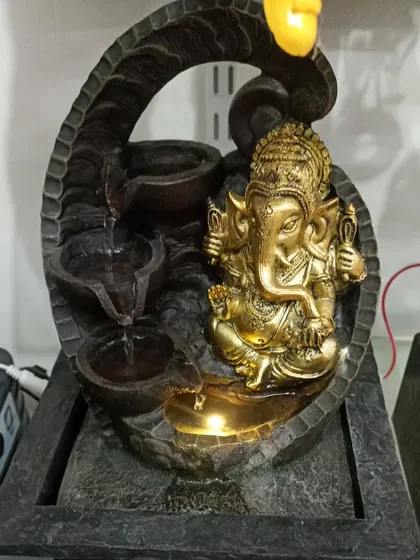 A Ganesha-themed tabletop water fountain. This decorative piece combines the calming element of water with a symbol of good fortune.