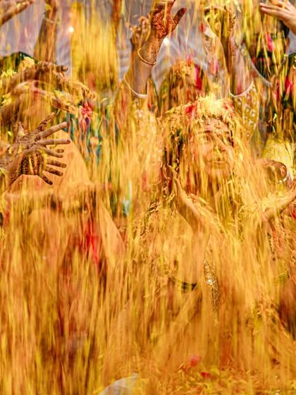 An explosion of yellow! A joyous and messy moment from a Haldi ceremony, where the bride is showered with flowers and turmeric.