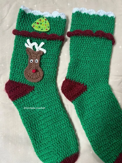 A detailed shot of the reindeer and tree appliques on our crochet Christmas stockings. Each element is crocheted separately and then carefully attached.
