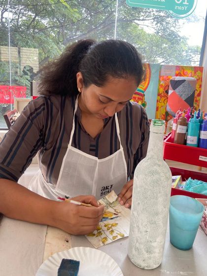 A participant works on her decoupage bottle. The studio provides all the materials you need to create your masterpiece.