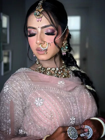 A close-up of a stunning bridal look with shimmery pink eyeshadow and a soft lip. I love creating these intricate looks that highlight the bride's features and complement her jewelry and outfit perfectly.