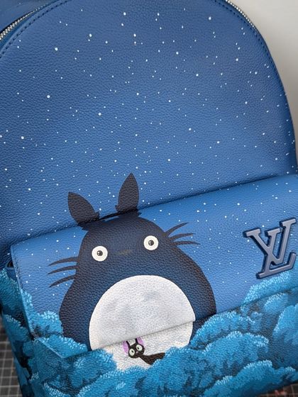 Here you can see how the artwork integrates with the bag's original features. Totoro peeks over the front pocket, right next to the LV logo, making it a true custom piece.