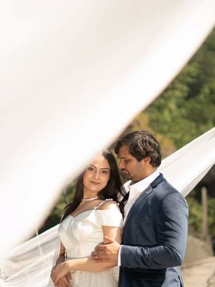 Using the veil trail as a foreground element adds a soft, dreamy quality to this intimate couple's portrait, showcasing the versatility of the gown's design.