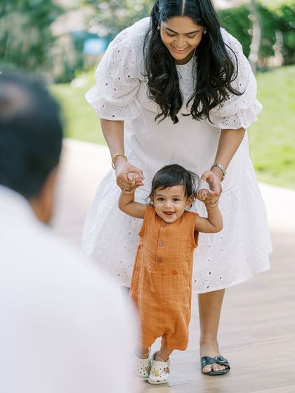 A baby taking his first steps towards his father. A precious milestone captured in a beautiful outdoor setting.