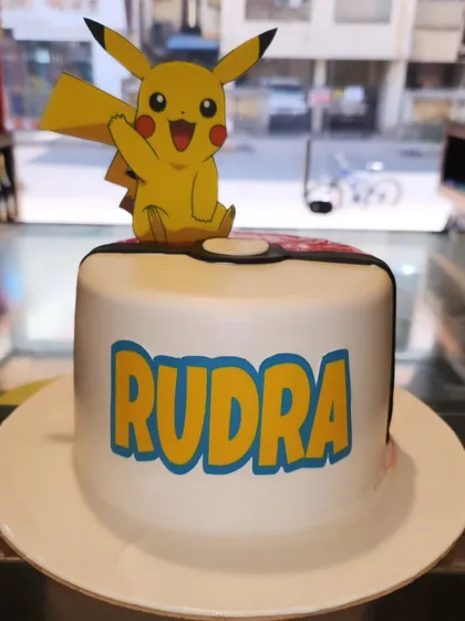 I choose you, Pikachu! This clean and simple Pokémon cake features the iconic character on top of a Poké Ball-inspired design, making it a perfect choice for a young Pokémon trainer's celebration.